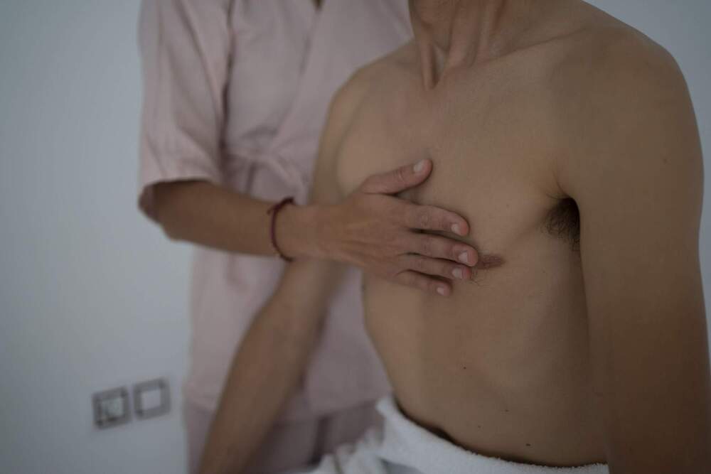 Terapeuta examinando el pecho de un hombre