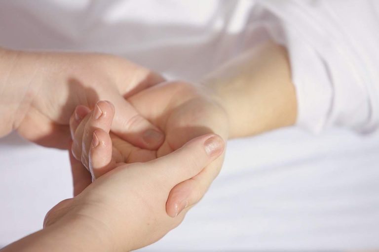 Dos manos sosteniendo la mano de otra persona